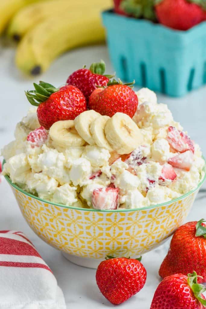 strawberry banana fluff recipe in a bowl with fresh strawberries and bananas