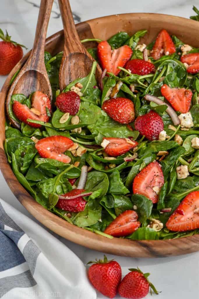 strawberry spinach salad in large bowl with balsamic dressing