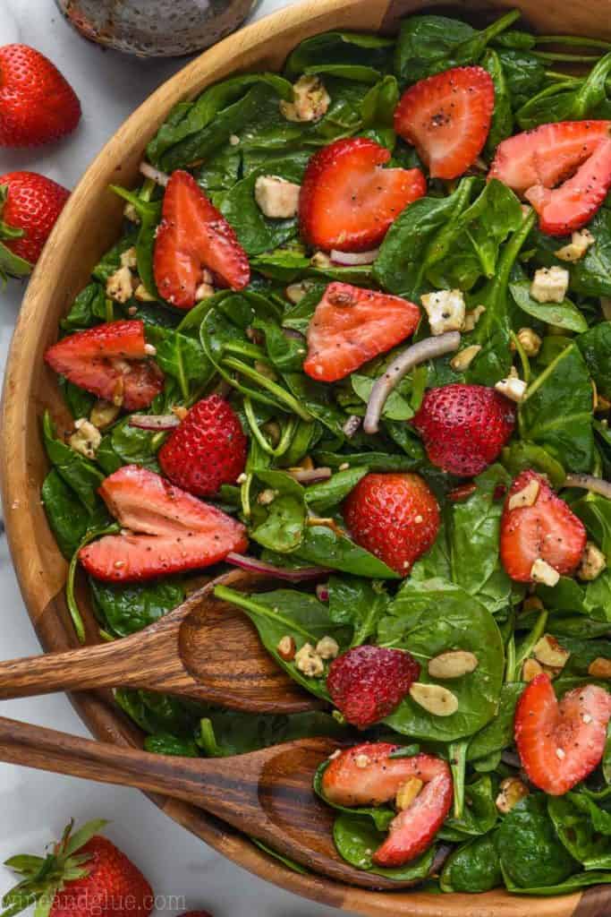 overhead view of strawberry spinach salad in wooden bowl