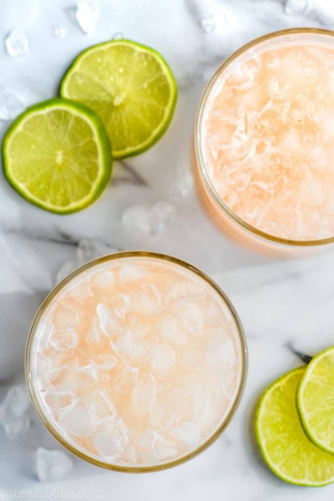 overhead view of two tumblers filled with ice and pink orange paloma drink recipe