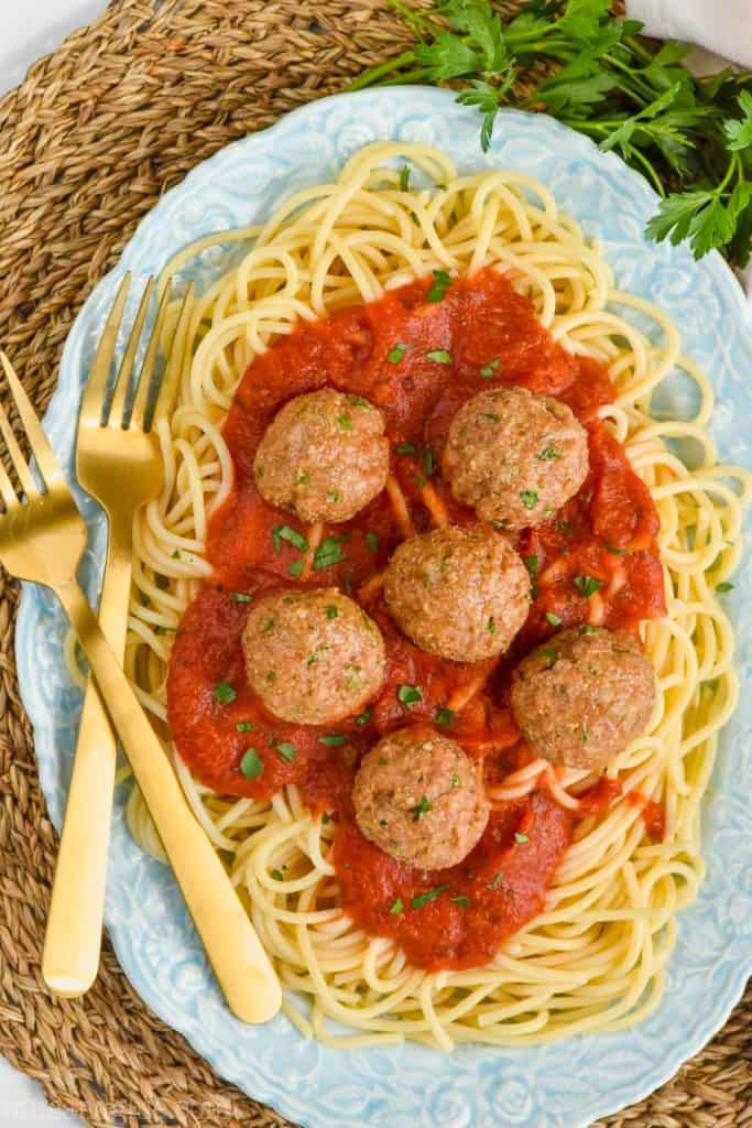 overhead view of baked turkey meatballs on a plate full of sauce and spaghetti