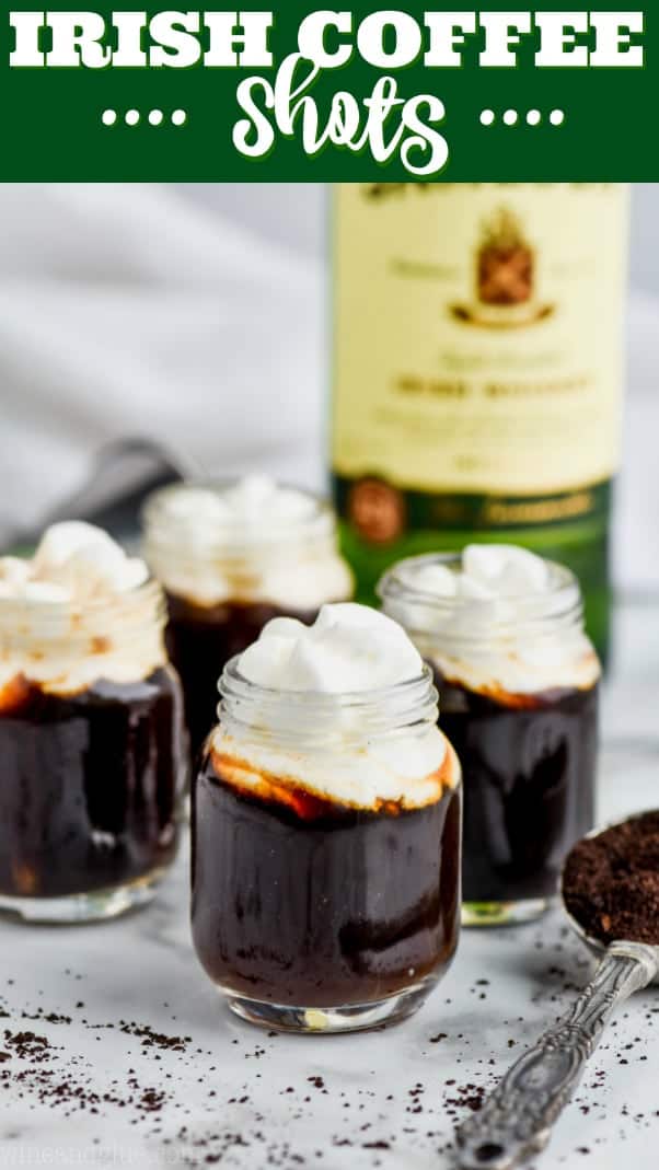 four shots of irish coffee topped with whipped cream