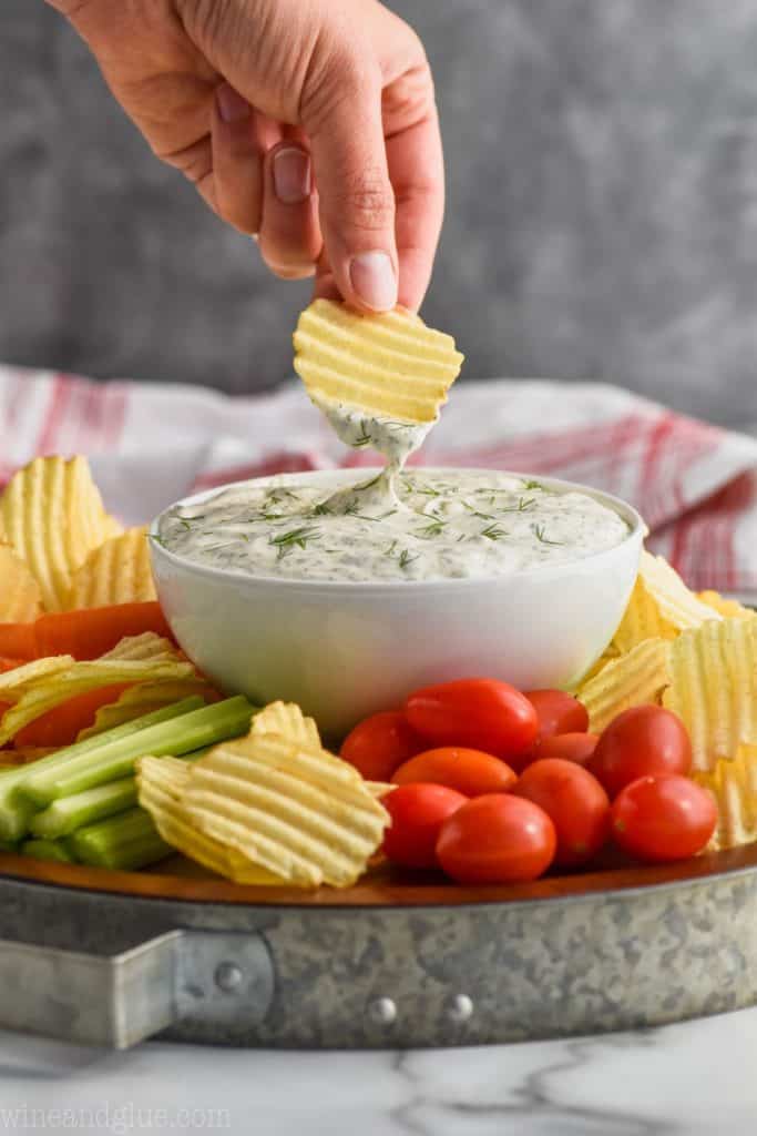 dipping into dill dip with potato chip