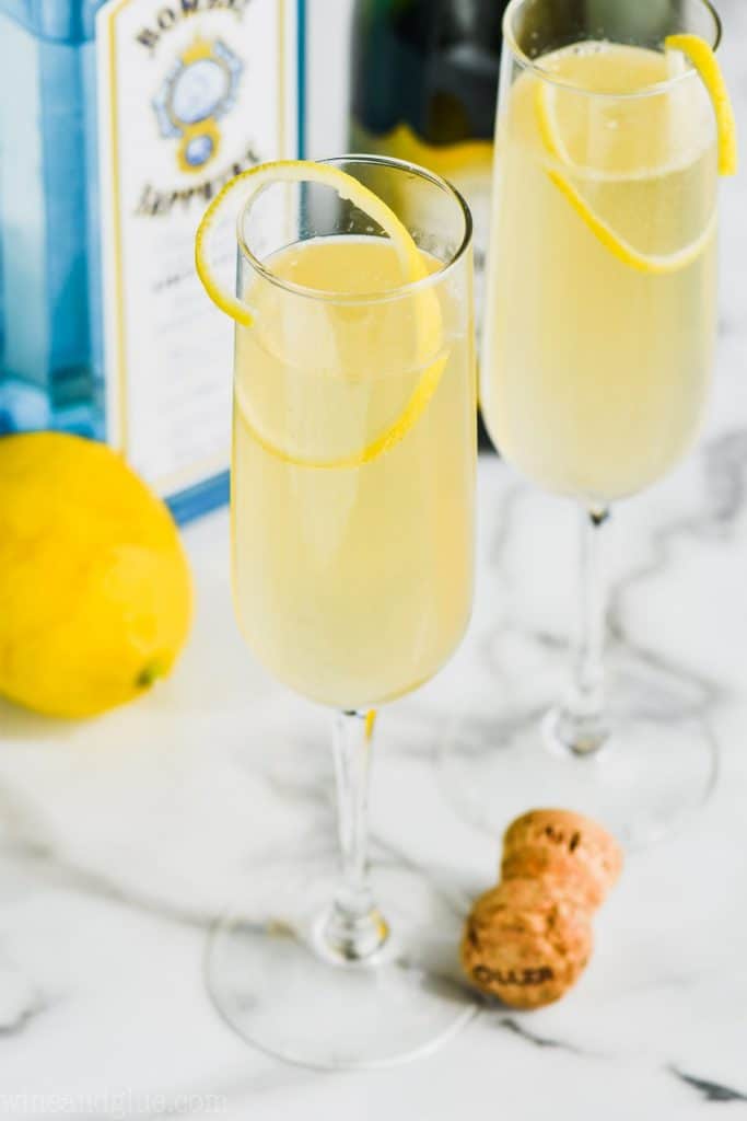 champagne flute garnished with lemon filled with a french 75 made with gin