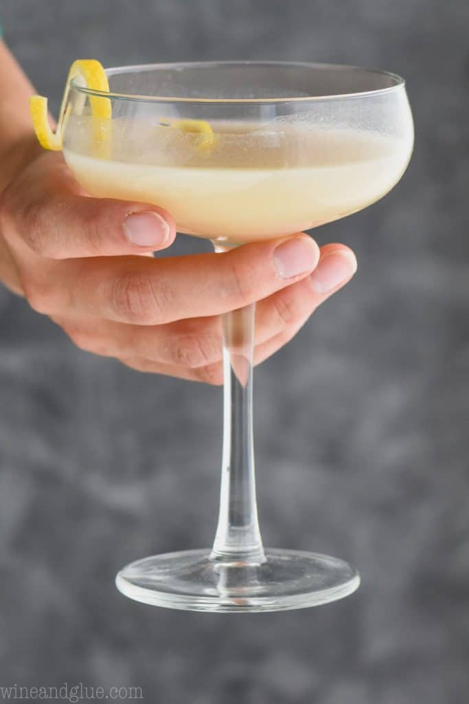 woman holding a glass full of saketini recipe