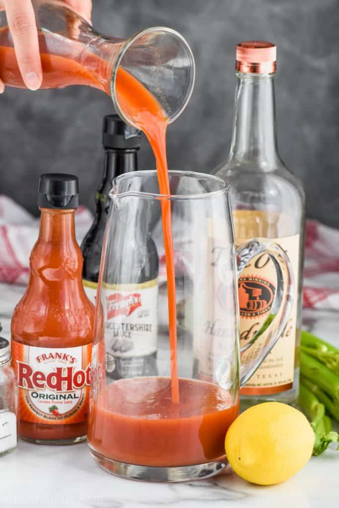 pouring tomato juice to make homemade bloody mary mix