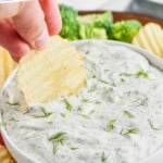 pinterest graphic of up close of chip being dipped into dill dip recipe, says: the best dill dip recipe simplejoy.com