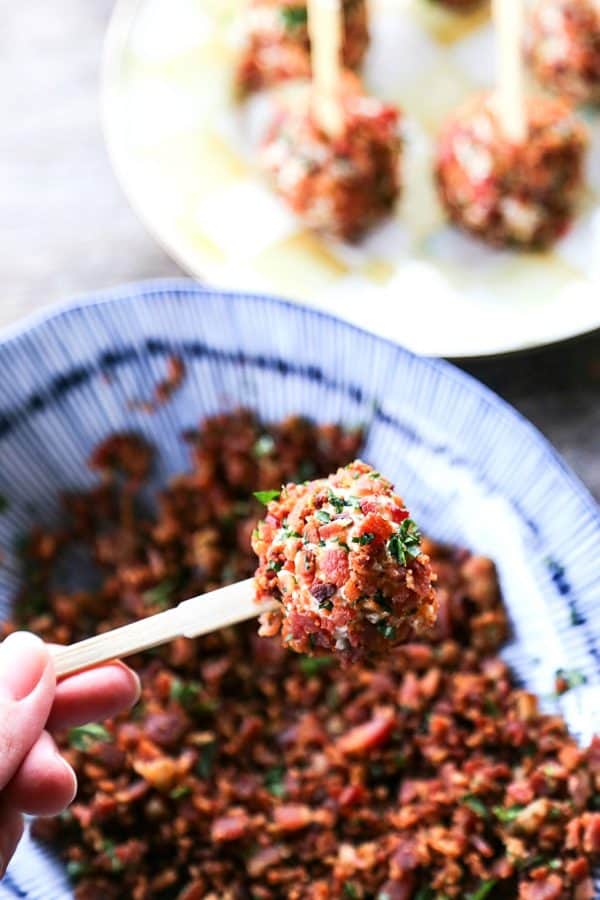 A closeup photo of a small Chicken Ranch Bacon Cheese Ball of a toothpick 