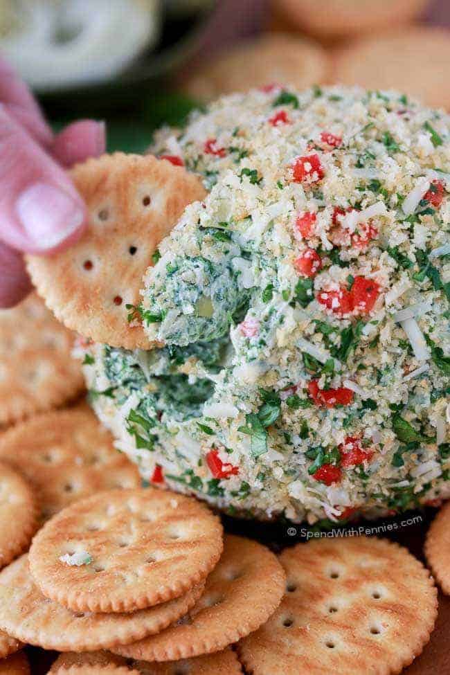 A Ritz Cracker is digging into the Spinach Artichoke Cheese Ball 