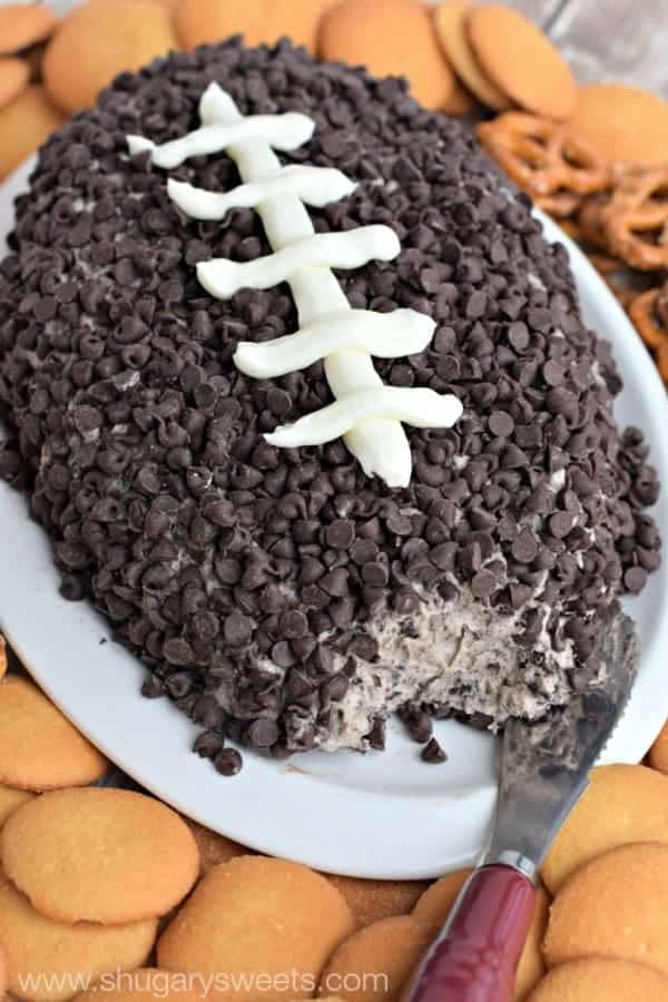 The Cookies and Cream Cheese Ball is in a shape of a football with frosting as the threads of the football. 