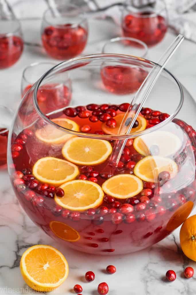 easy christmas punch recipe in a big punch bowl with oranges and cranberries