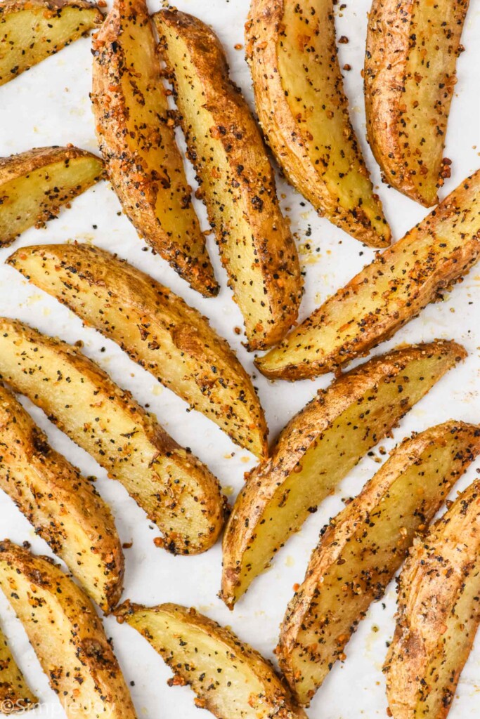 overhead of potato wedges on a rimmed baking sheet after baking