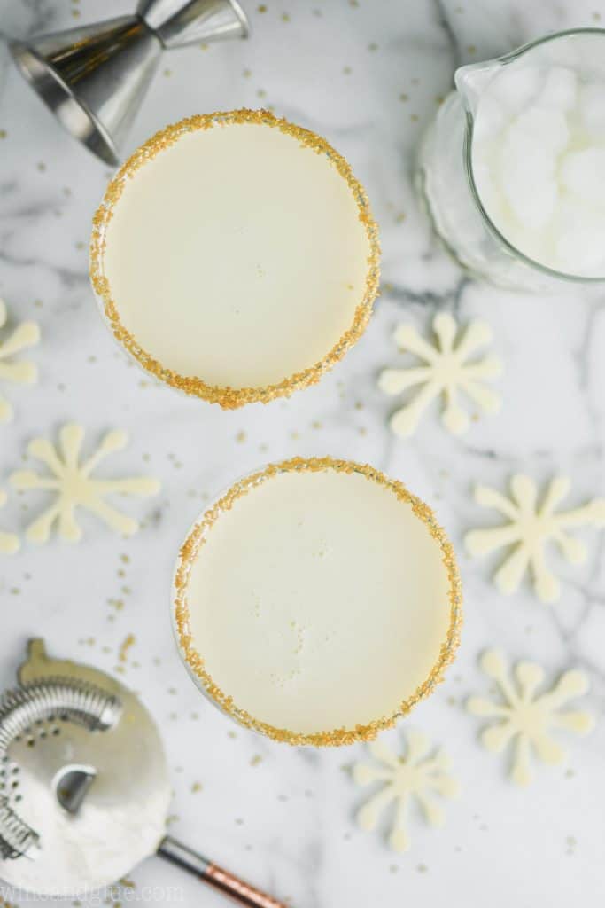 overhead view of two christmas martini glasses rimmed with gold sugar