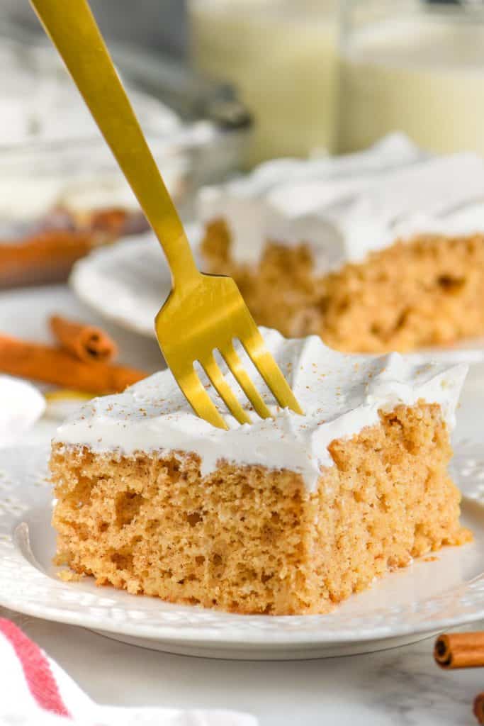 golden fork digging into a eggnog poke cake