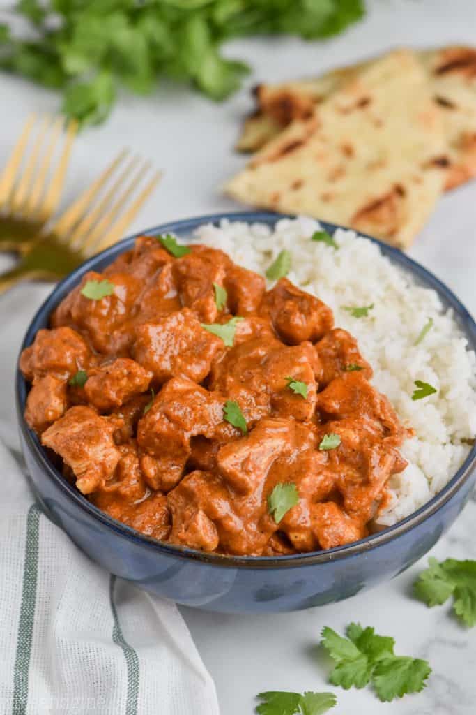 bowl of indian butter chicken recipe with rice and cilantro