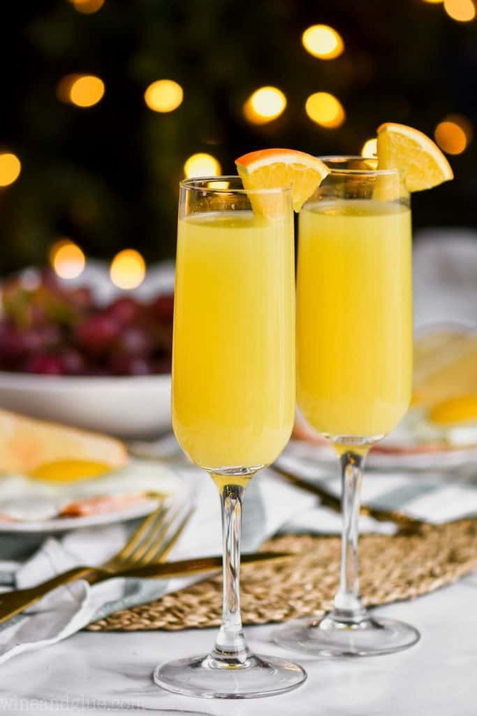 two glasses of non alcoholic mimosas on a brunch table