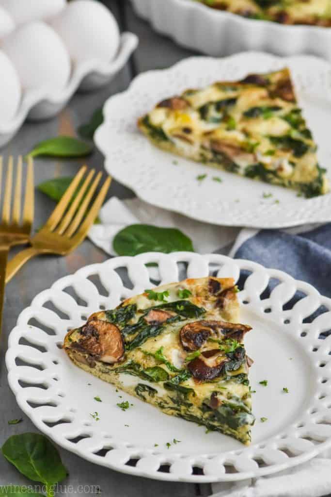 pice of crustless spinach quiche on a white plate with another piece in the background