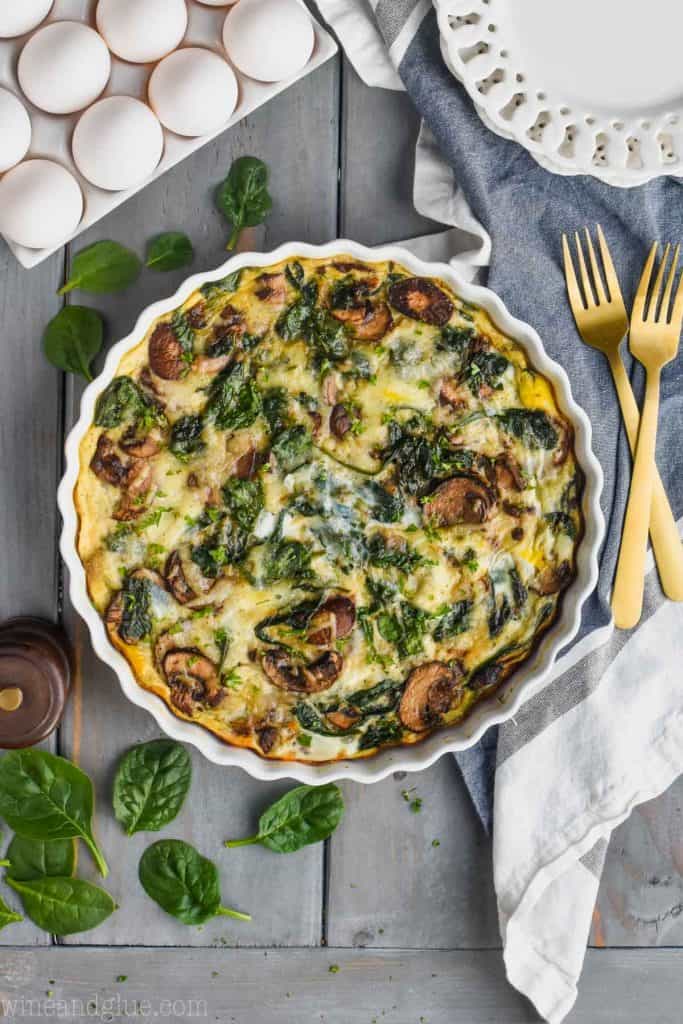 overhead view of a crustless spinach quiche recipe in a white quiche dish