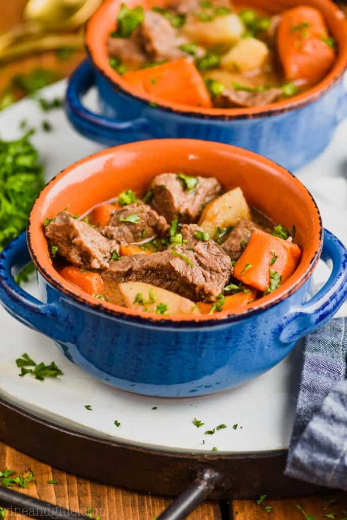 instant pot beef stew in a blue bowl garnished with parsley