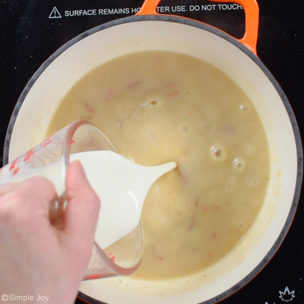 adding heavy cream to a roux in a small saucepan