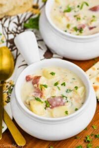 small white soup bowl full of new england clam chowder recipe and garnished with parsley