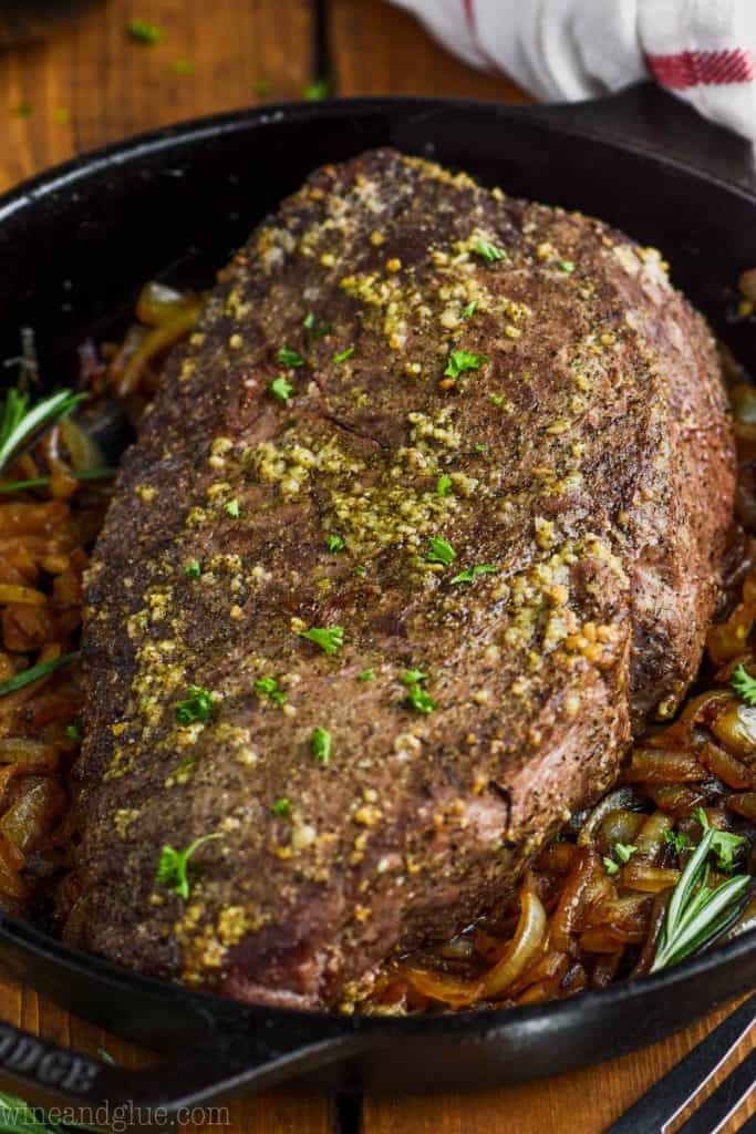 easy roast beef in a cast iron skillet with caramelized onions