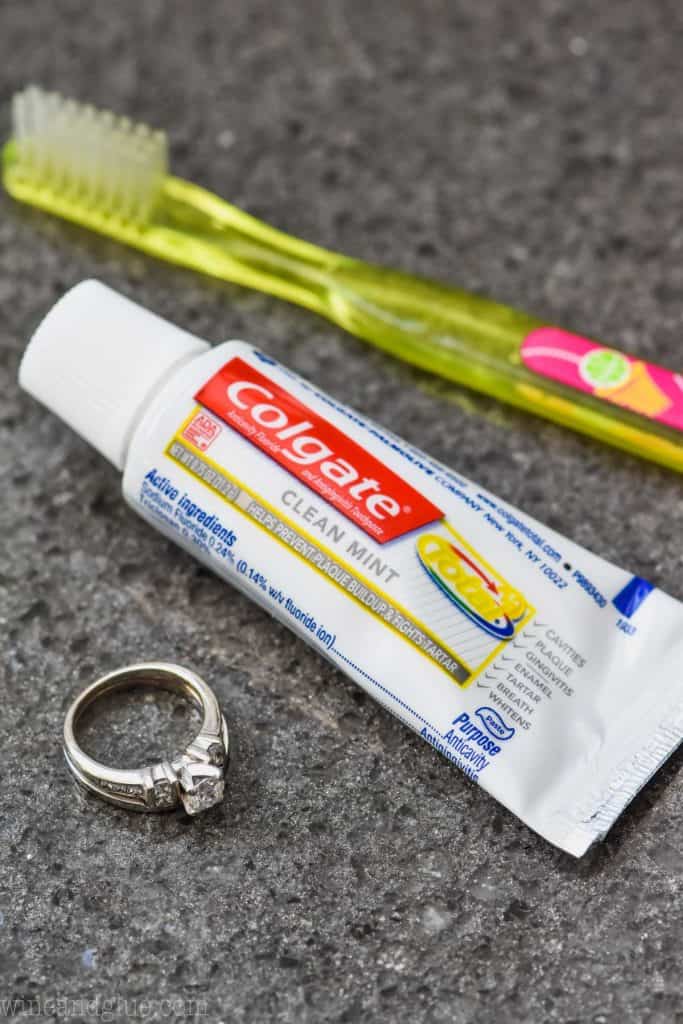 toothpaste and toothbrush on counter with diamond ring to clean it