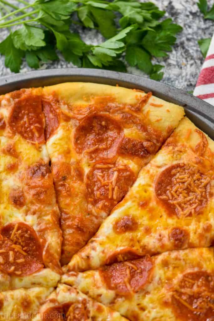 close up overhead picture of a pepperoni pizza divided into slices made with homemade pizza sauce