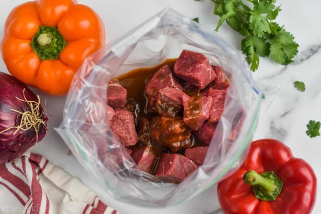 cut up steak in a plastic bag covered in steak fajita marinade to make steak kabobs