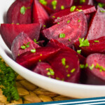 pinterest graphic of a white bowl on a wood mat filled with wedges of roasted beets sprinkled with parsley, says: roasted beets simplejoy.com