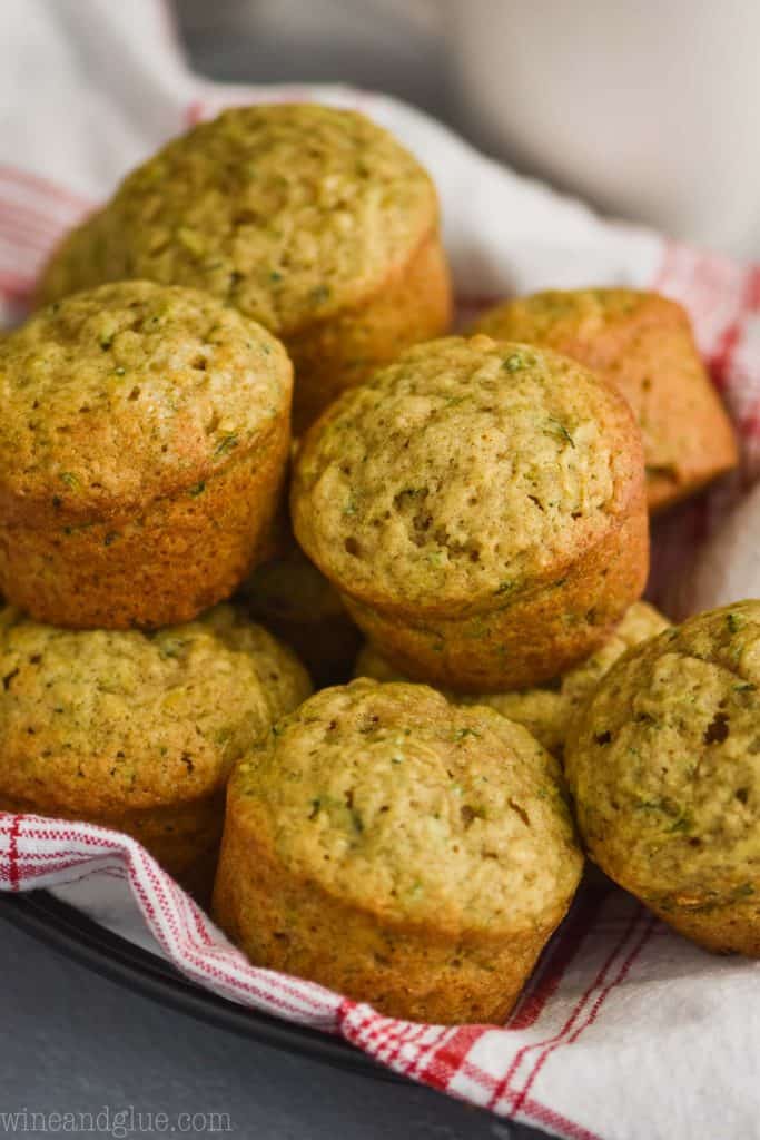 a basket lined with white and red checked fabric napikin holding zucchini muffins