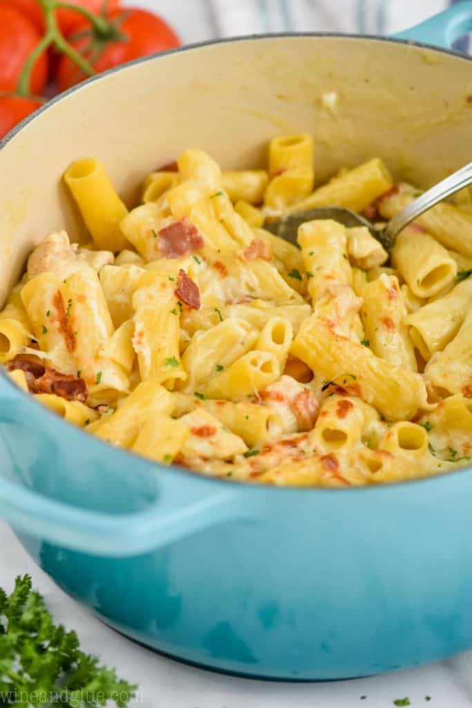 teal dutch oven filled with rigatoni noodles that have been baked with chicken and bacon for chicken bacon ranch pasta