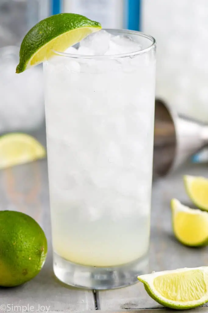 close up view of a gin rickey cocktail in a tall glass garnished with a lime wedge