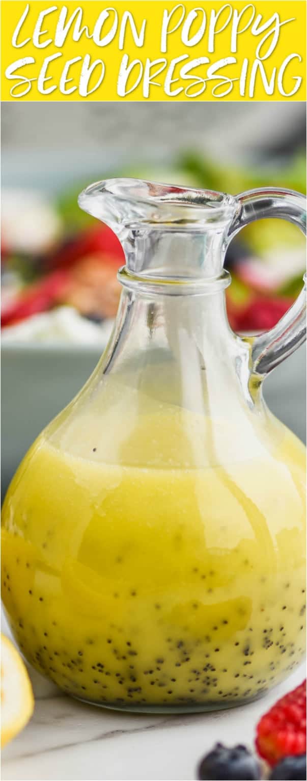 vinaigrette bottle surrounded by cut lemons, fresh raspberries and blueberries and filled with lemon poppy seed salad dressing