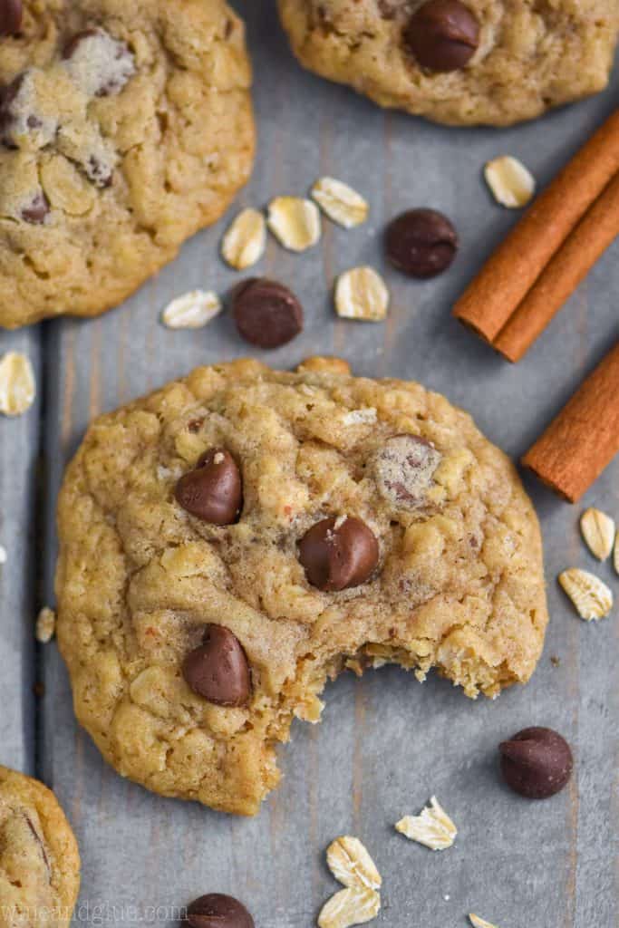 overhead view of the best oatmeal chocolate chip cookies on a blue wood board with oatmeal and chocolate chips around it