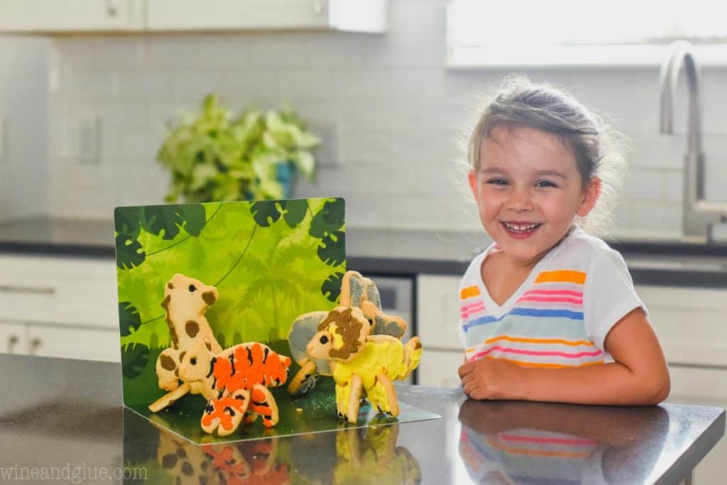 little girl with animal cookies that have been frosted