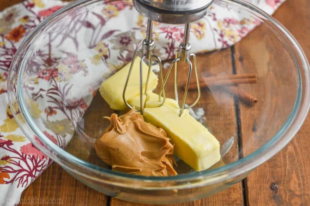 large bowl with peanut butter and butter about to be mixed by a hand mixer