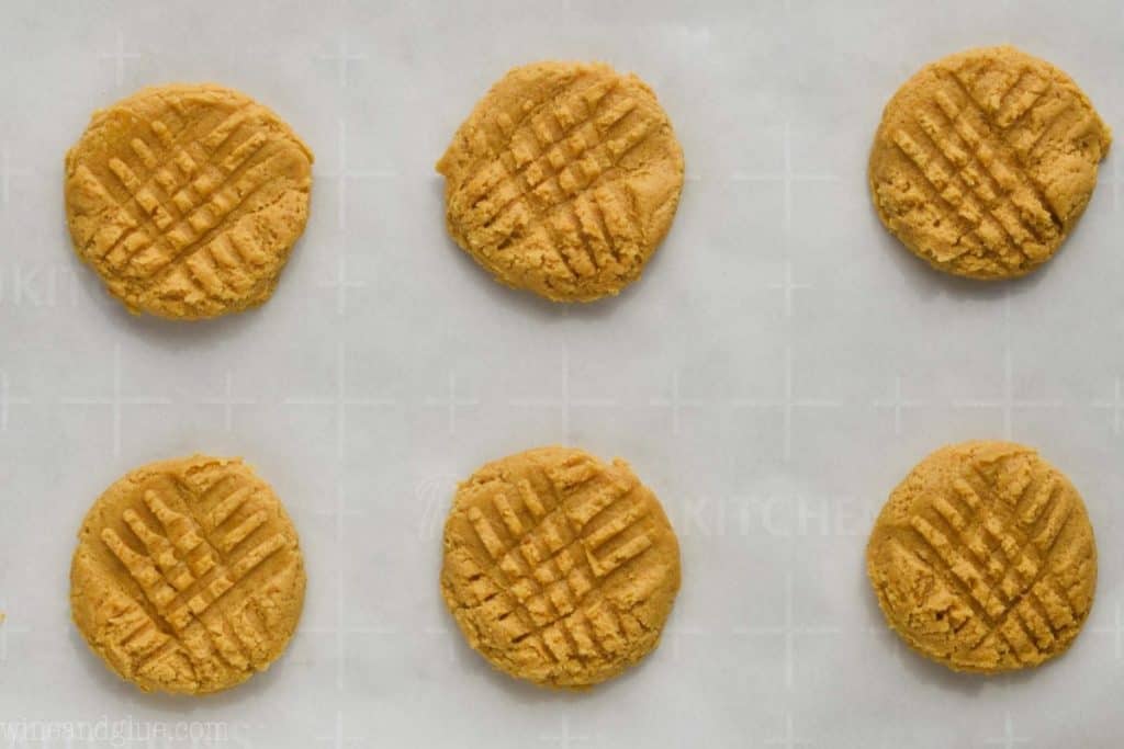 six pumpkin peanut butter cookies on parchment paper ready to be baked