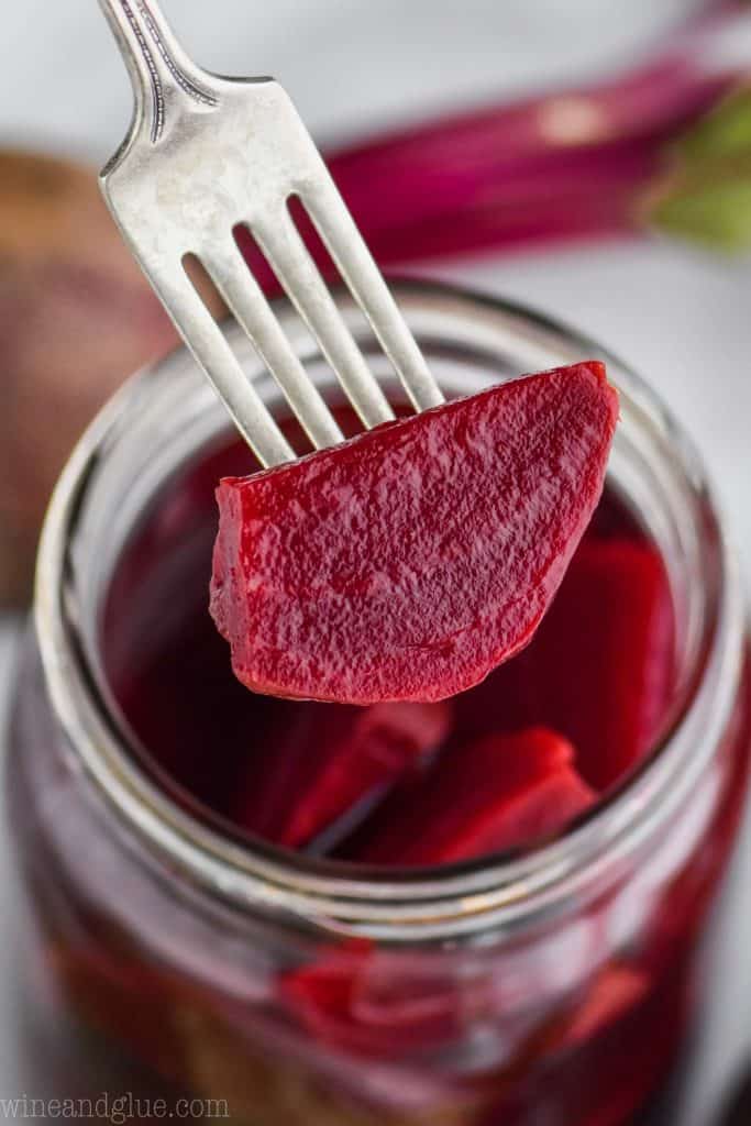 quick pickled beet on a fork over a jar of them