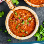 pinterest graphic of overhead view of a brown bowl with a handle holding vegetarian bean chili recipe garnished with cilantro on a dark surface with more cilantro around it, says: vegetarian chili simplejoy.com