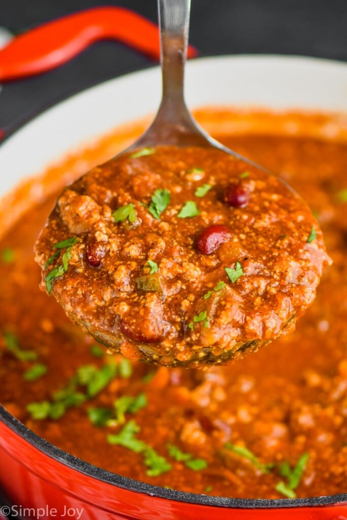 a vegetarian chili recipe being ladled out of a red stock pot