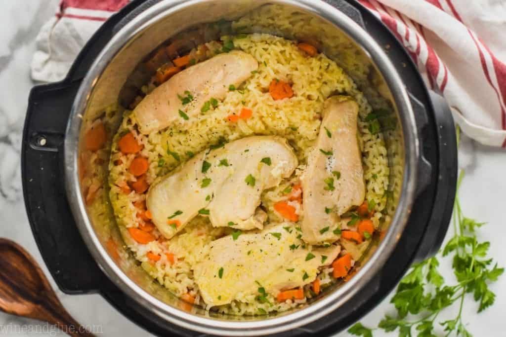 landscape photo of chicken on a bed of carrots and rice after cooking an instant pot