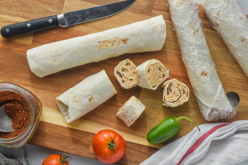 a mexican pinwheel appetizer being cut up on a cutting board