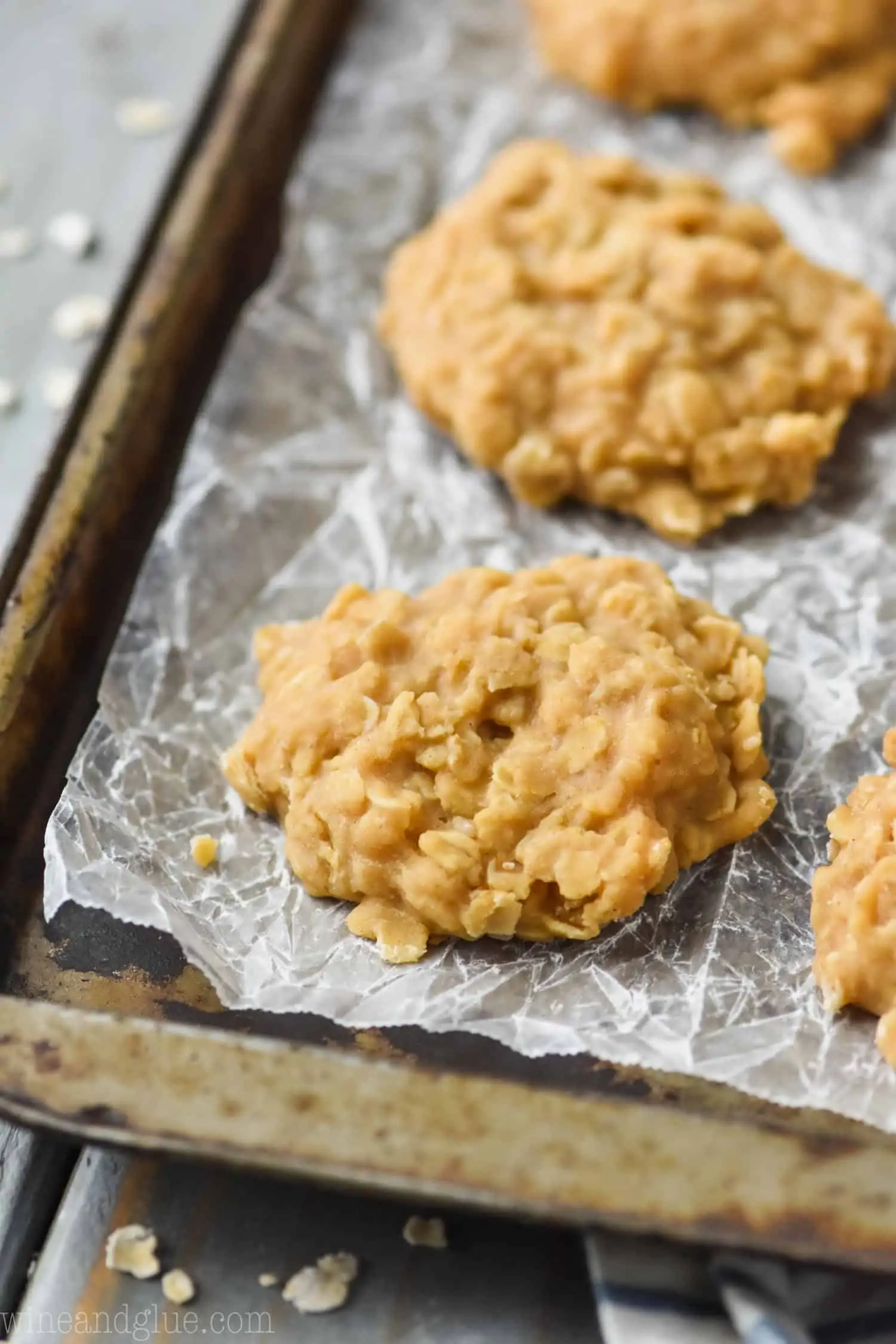 close up of a no bake peanut butter oatmeal cookie on crinkled wax paper on a old baking sheet