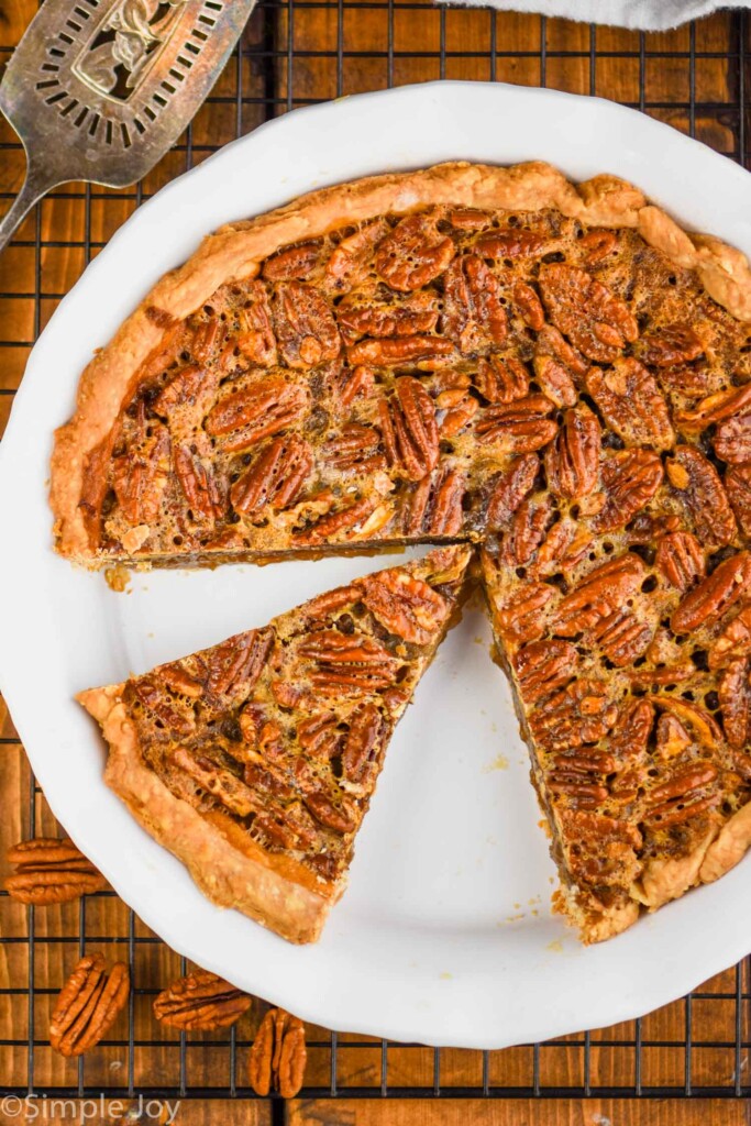 overhead view of a pecan pie that has been cut into with a piece sitting waiting to be pulled out