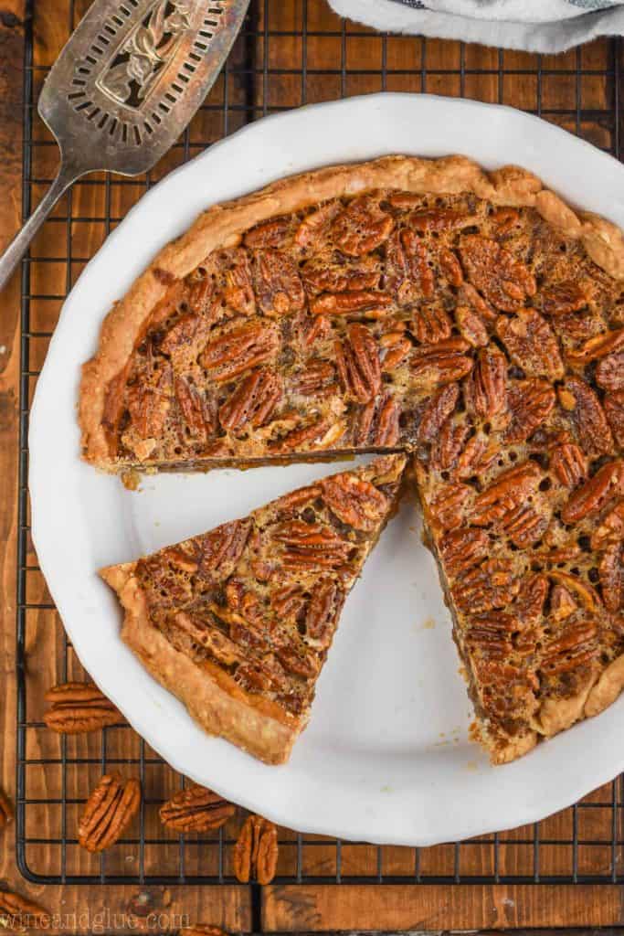 overhead view of a pecan pie that has been cut into with a piece sitting waiting to be pulled out