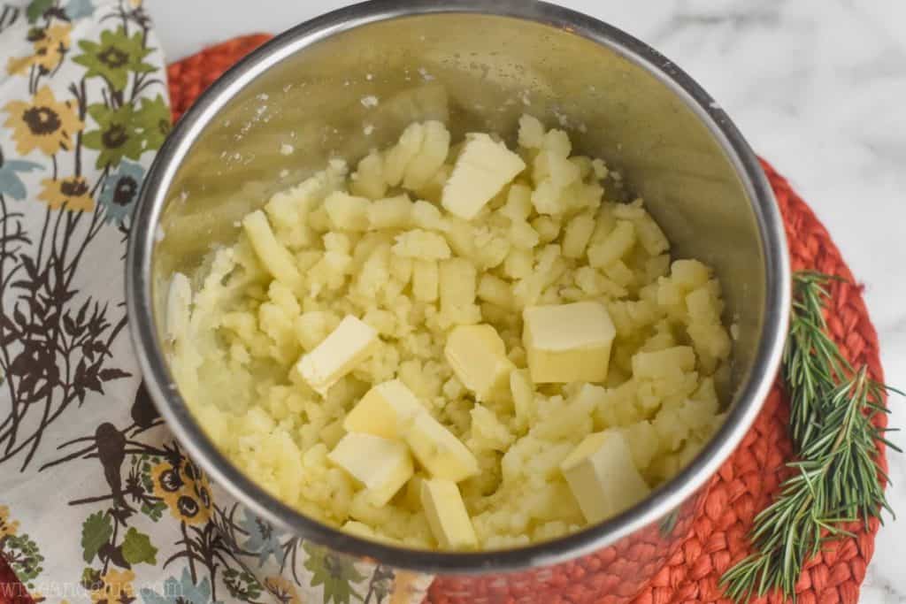 tabs of butter on top of cooked potatoes in an instant pot