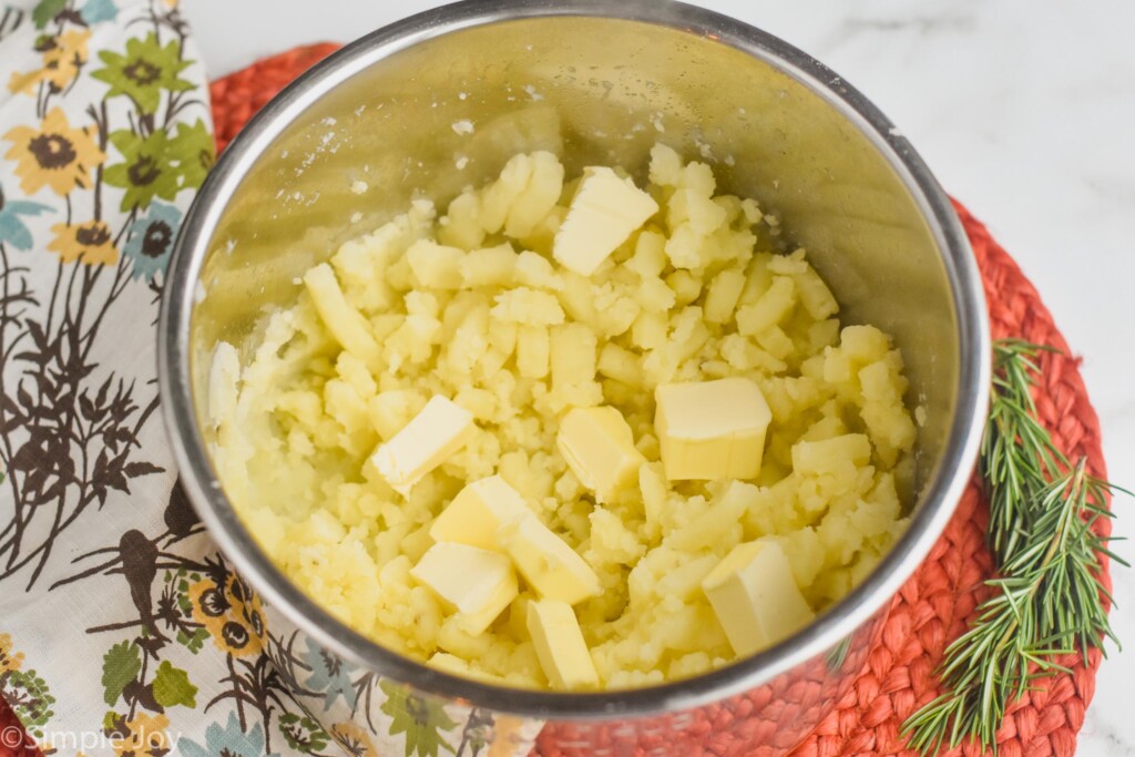 tabs of butter on top of cooked potatoes in an instant pot