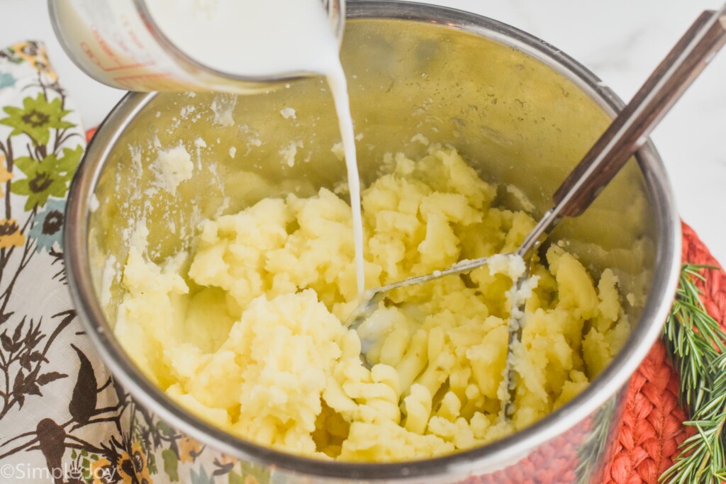 milk being poured into the bowl of an instant pot that has instant pot mashed potatoes in it