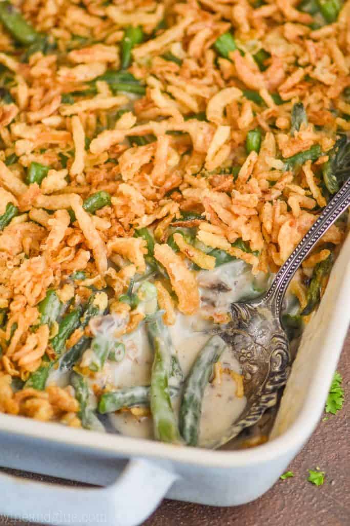 an antique spoon dishing into a casserole dish of green bean casserole recipe